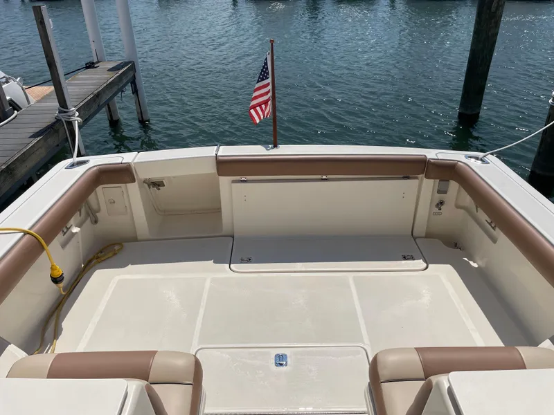 Slide: The Image of 1998 Tiara Yachts 3500 Open boat deck with American flag, docked by the water. - 6