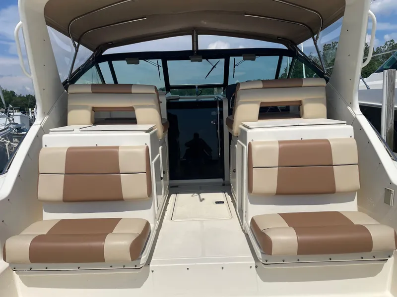 Slide: The Image of 1998 Tiara Yachts 3500 Open interior with tan and cream seating, under a canopy. - 8