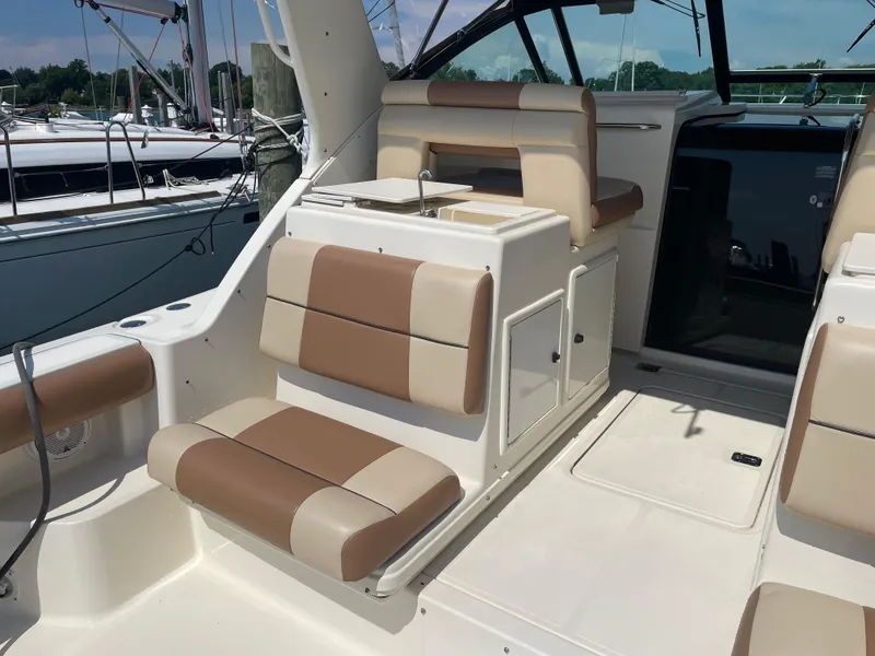 Slide: The Image of 1998 Tiara Yachts 3500 Open interior with beige and brown seating, docked at marina. - 9