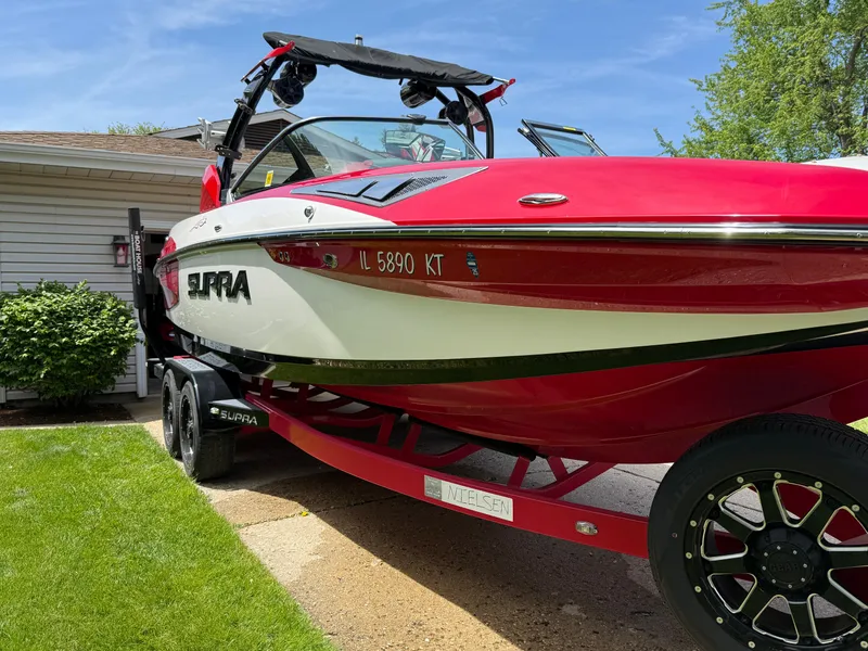 Slide: The Image of Red and white 2015 Supra SE450-550 boat on trailer, parked in driveway. - 4