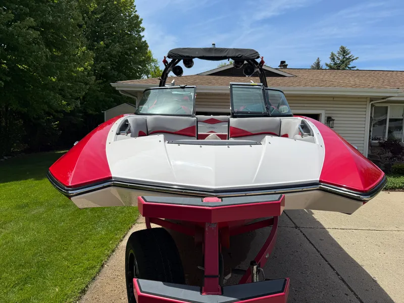 Slide: The Image of 2015 Supra SE450-550 boat with red and white design on a driveway. - 6