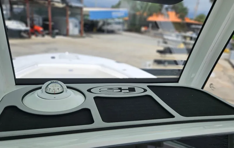 Slide: The Image of 2025 Sea Hunt Gamefish 28 FS dashboard with compass and storage compartments. - 19