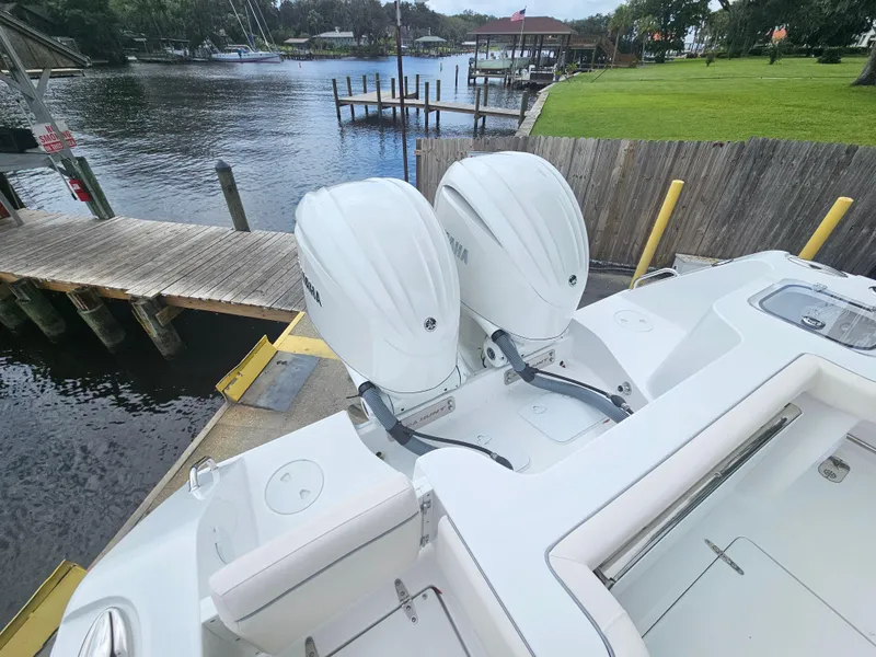 Slide: The Image of 2025 Sea Hunt Gamefish 28 FS with dual outboard motors docked by a serene waterfront. - 38