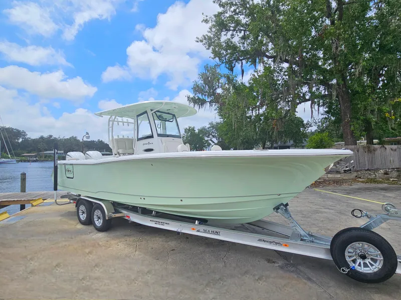 Slide: The Image of 2025 Sea Hunt Gamefish 28 FS boat on trailer, parked outdoors under a blue sky. - 4