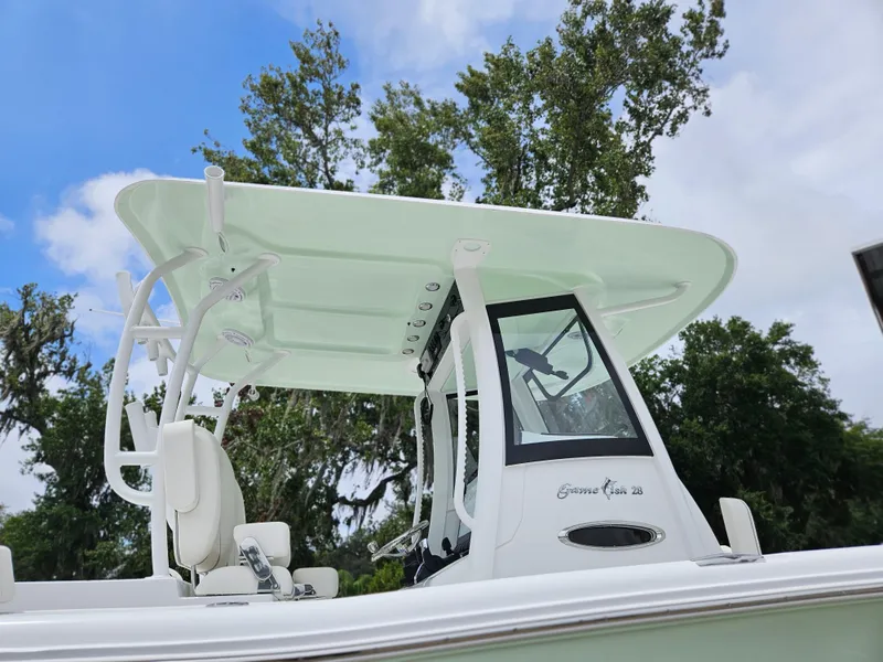 Slide: The Image of 2025 Sea Hunt Gamefish 28 FS boat with T-top against a blue sky. - 9