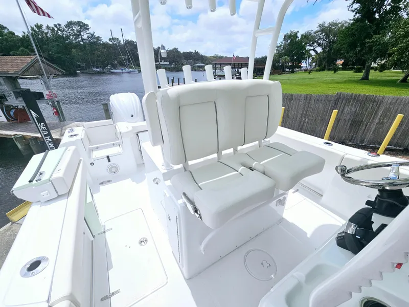 Slide: The Image of 2025 Sea Hunt Gamefish 28 FS boat interior with white seating and steering wheel. - 11