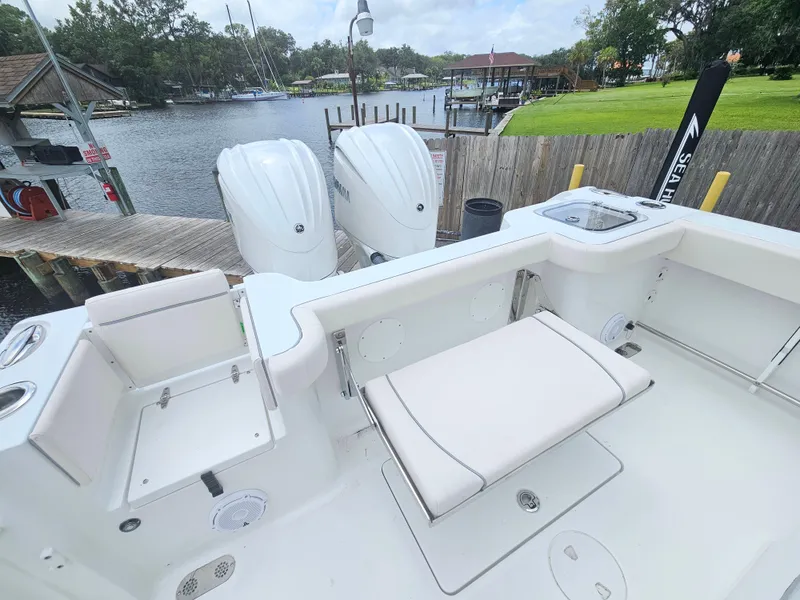 Slide: The Image of 2025 Sea Hunt Gamefish 28 FS boat with dual engines docked by a serene waterfront. - 15