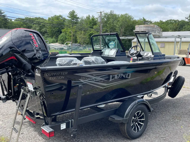 Slide: The Image of 2026 Lund 1800 Explorer Sport boat with Mercury Pro XS engine, parked outdoors. - 1