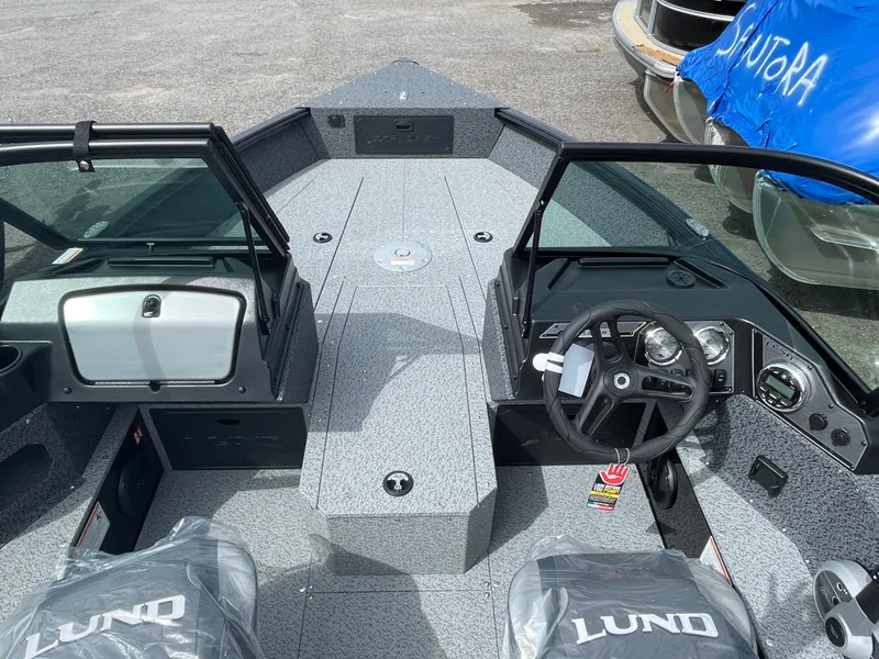 Slide: The Image of 2026 Lund 1800 Explorer Sport boat interior with steering wheel and dashboard. - 2