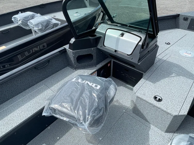 Slide: The Image of 2026 Lund 1800 Explorer Sport boat interior with protective seat covers and modern dashboard. - 4