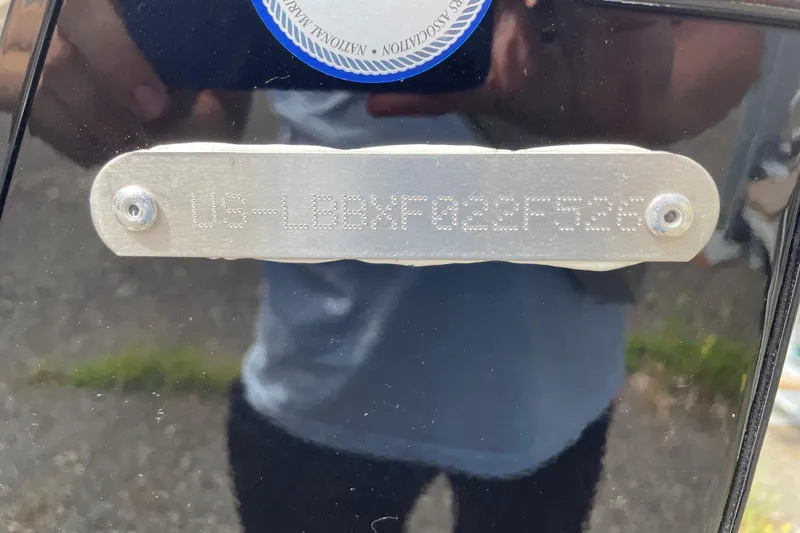 Slide: The Image of VIN plate on 2026 Lund 1800 Explorer Sport boat, reflecting surroundings. - 9