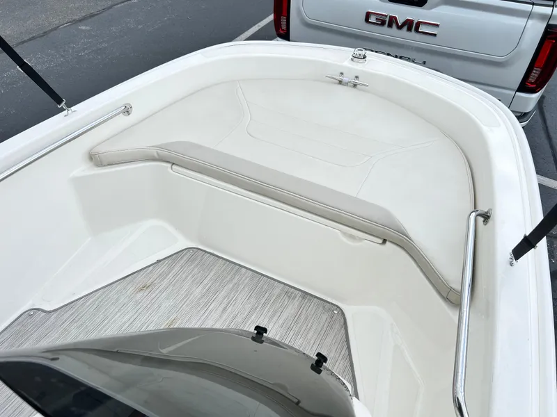 Slide: The Image of 2022 Boston Whaler 130 Super Sport interior with seating, parked near a GMC vehicle. - 10