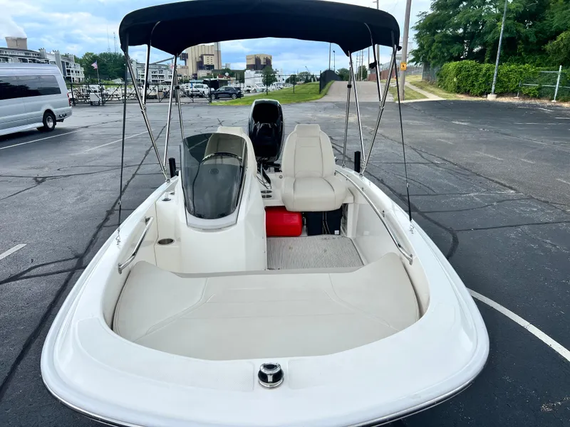 Slide: The Image of 2022 Boston Whaler 130 Super Sport boat with canopy, parked in a lot. - 11