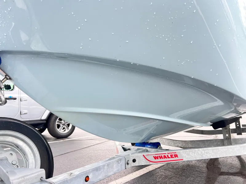 Slide: The Image of 2022 Boston Whaler 130 Super Sport boat on trailer, close-up view. - 12