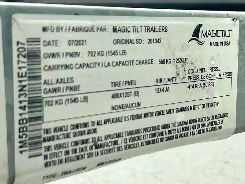 Slide: The Image of Label on Magic Tilt trailer for 2022 Boston Whaler 130 Super Sport, showing specifications and safety standards. - 16