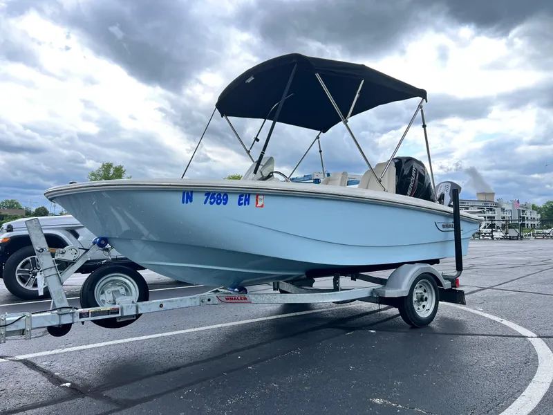 Slide: The Image of 2022 Boston Whaler 130 Super Sport boat on trailer, under cloudy sky. - 3