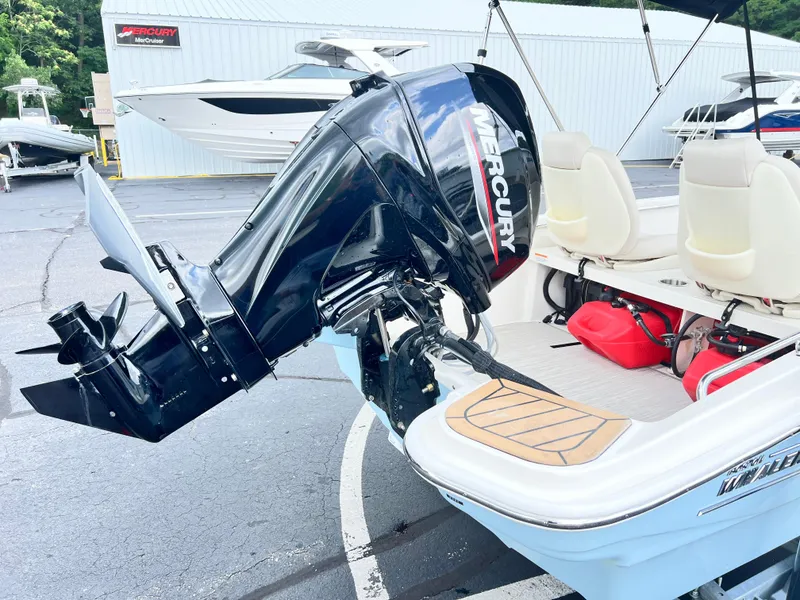 Slide: The Image of 2022 Boston Whaler 130 Super Sport with Mercury outboard motor, docked at a marina. - 5