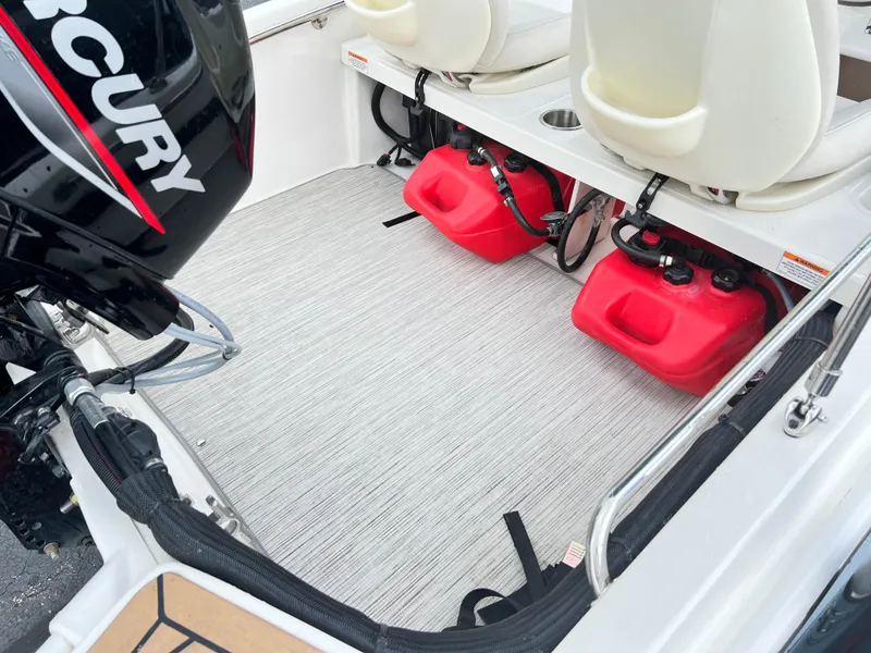Slide: The Image of 2022 Boston Whaler 130 Super Sport interior with Mercury engine and red fuel tanks. - 6