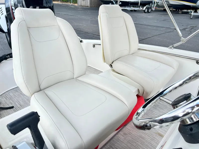 Slide: The Image of 2022 Boston Whaler 130 Super Sport interior with white seats and steering wheel. - 7