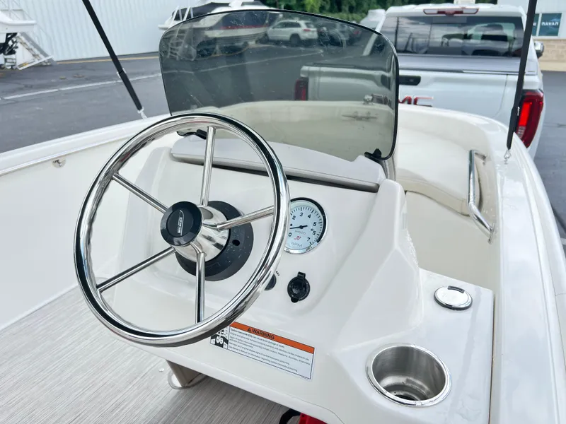 Slide: The Image of 2022 Boston Whaler 130 Super Sport boat dashboard with steering wheel and gauge. - 8