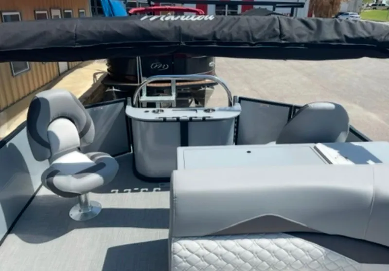 Slide: The Image of 2021 Manitou 24 Encore Pro Angler PT boat interior with seating and helm station. - 2