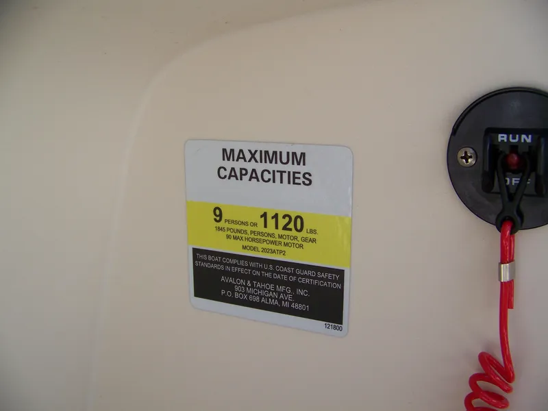 Slide: The Image of 2023 Avalon Venture Rear Fish boat capacity label, 9 persons or 1120 lbs, safety compliance. - 8