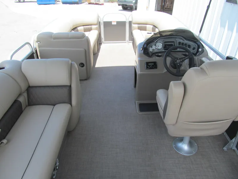 Slide: The Image of 2023 Sun Tracker Party Barge 20 DLX interior with beige seating and steering console. - 5
