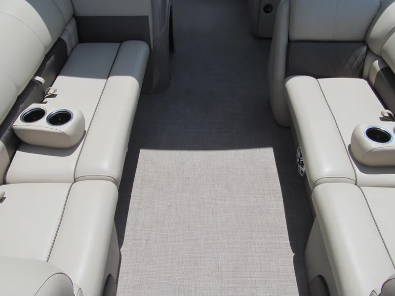 Slide: The Image of 2023 Sun Tracker Party Barge 20 DLX interior with beige seating and cup holders. - 8