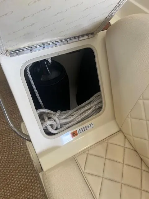 Slide: The Image of 2018 Chris-Craft Launch 27 storage compartment with rope and fender, featuring quilted upholstery. - 10