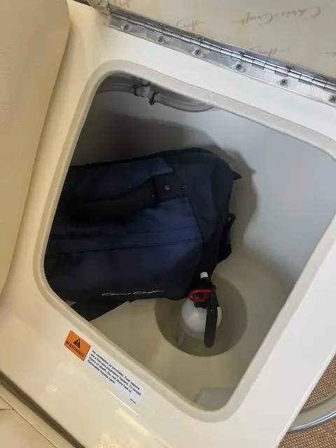 Slide: The Image of Storage compartment in 2018 Chris-Craft Launch 27 with bag and fire extinguisher. - 11
