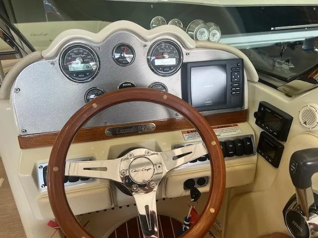 Slide: The Image of 2018 Chris-Craft Launch 27 dashboard with wooden steering wheel and modern gauges. - 21