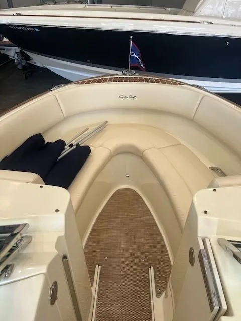 Slide: The Image of 2018 Chris-Craft Launch 27 boat interior with beige seating and nautical flag. - 23