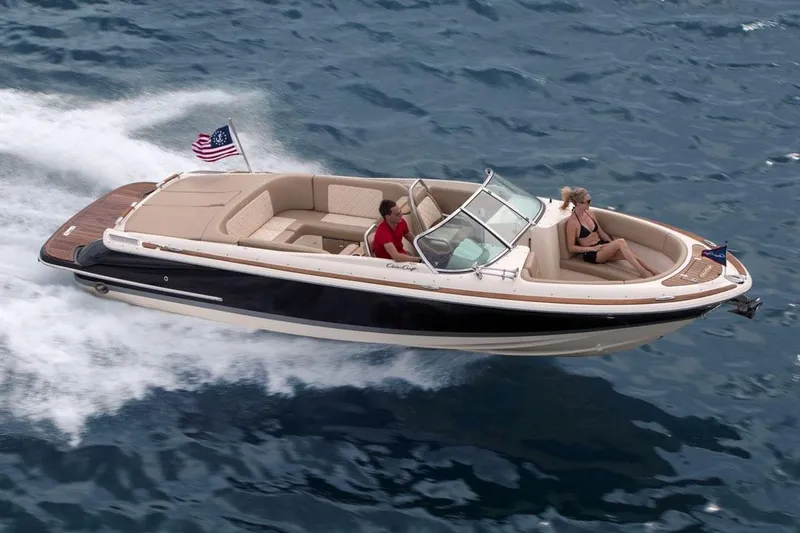 Slide: The Image of 2018 Chris-Craft Launch 27 boat cruising on open water, featuring sleek design and luxury seating. - 24