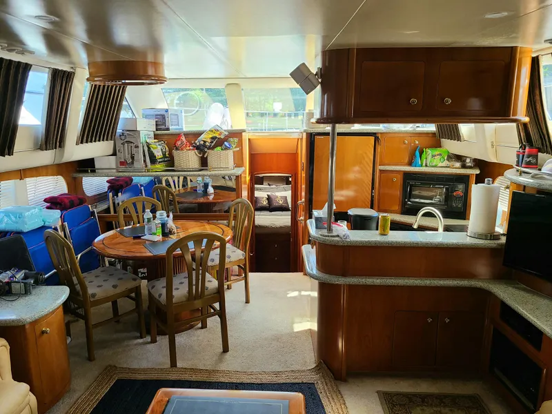 Slide: The Image of Interior of 2001 Carver 506 Motor Yacht with dining area and kitchen amenities. - 26