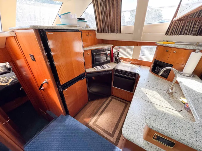 Slide: The Image of Interior of 2001 Carver 506 Motor Yacht kitchen with appliances and wood cabinetry. - 27
