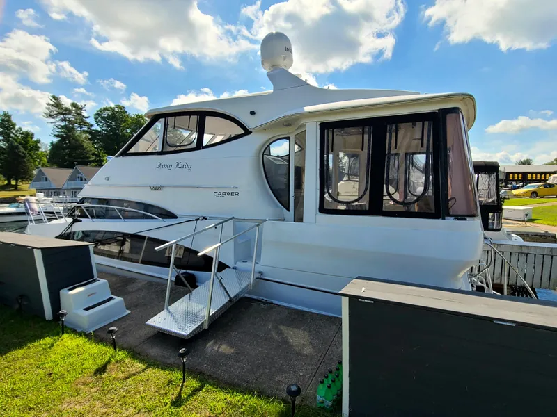 Slide: The Image of 2001 Carver 506 Motor Yacht docked, featuring sleek design and spacious cabin under a clear sky. - 4
