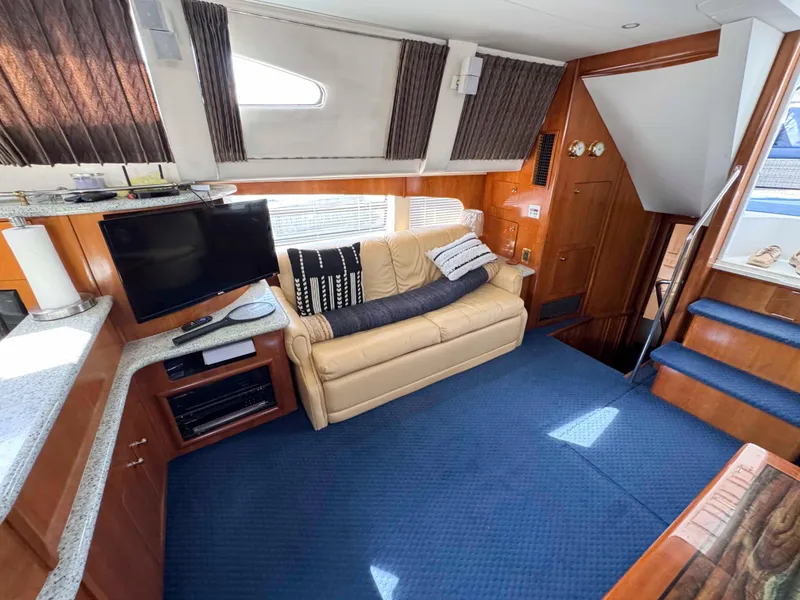 Slide: The Image of Interior of 2001 Carver 506 Motor Yacht with sofa, TV, and blue carpet. - 24