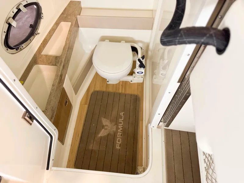 Slide: The Image of Interior of 2016 Formula 290 Bowrider boat bathroom with toilet and porthole. - 17