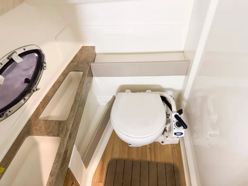 Slide: The Image of 2016 Formula 290 Bowrider boat bathroom with toilet and porthole window. - 18