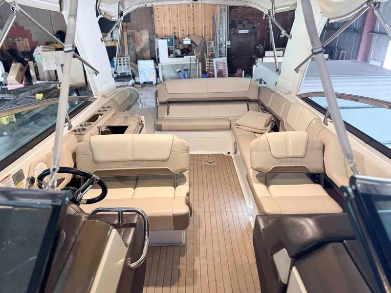 Slide: The Image of 2016 Formula 290 Bowrider interior with beige seating and wood flooring in a garage setting. - 6