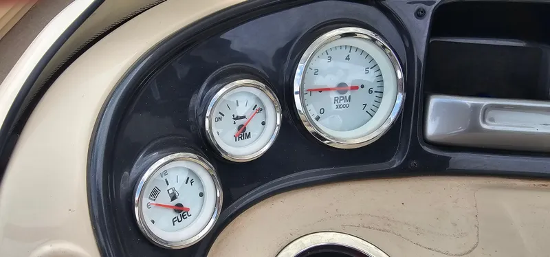 Slide: The Image of Dashboard gauges of a 2018 Sun Tracker PB-18 DLX boat, showing RPM, trim, and fuel levels. - 10