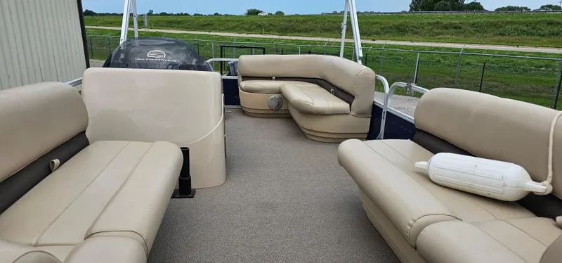 Slide: The Image of 2018 Sun Tracker PB-18 DLX pontoon boat with beige seating and open deck layout. - 4