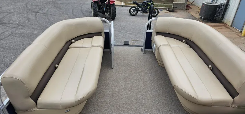 Slide: The Image of 2018 Sun Tracker PB-18 DLX pontoon boat interior with beige seating and spacious layout. - 5
