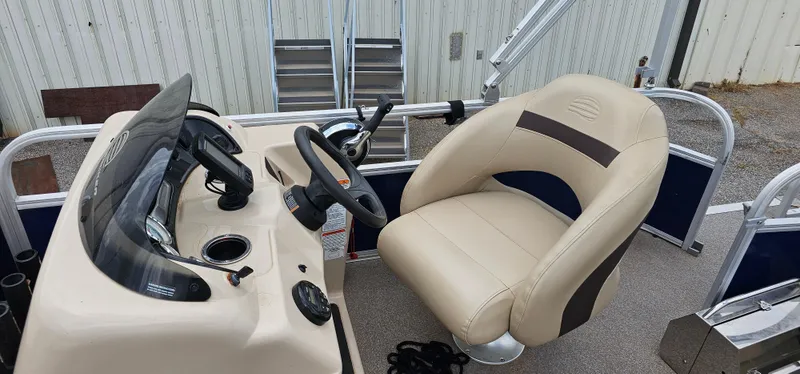 Slide: The Image of 2018 Sun Tracker PB-18 DLX boat interior with steering console and beige captain's chair. - 7