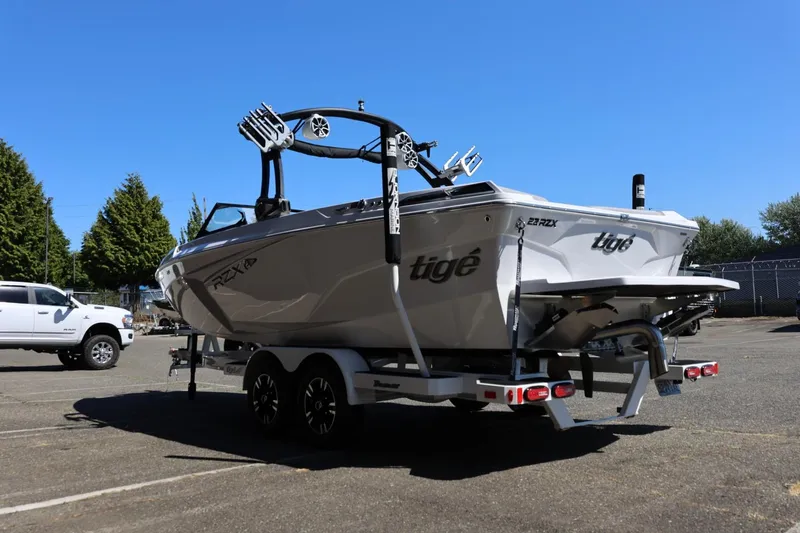 Slide: The Image of 2021 Tigé 22RZX boat on trailer in parking lot, clear sky background. - 12