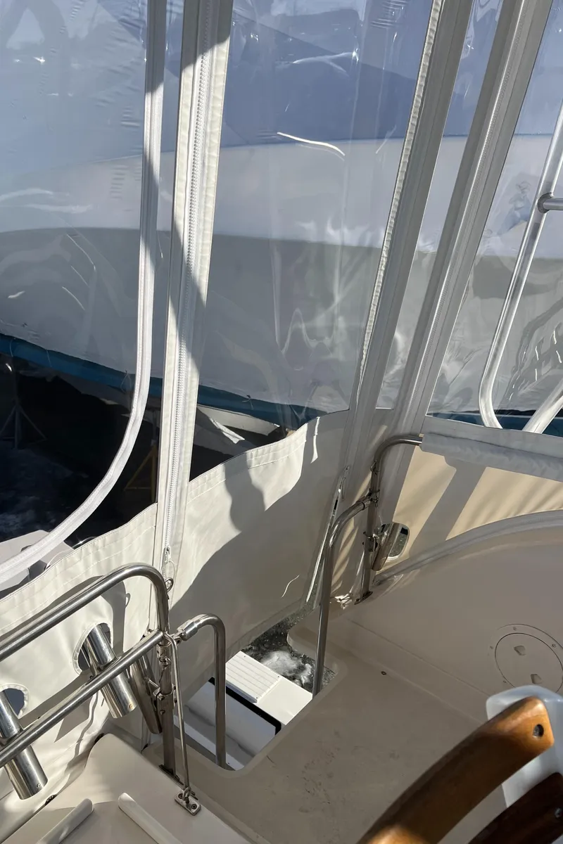 Slide: The Image of 1992 Blackfin 29 Flybridge interior with clear enclosure and stainless steel railings. - 10