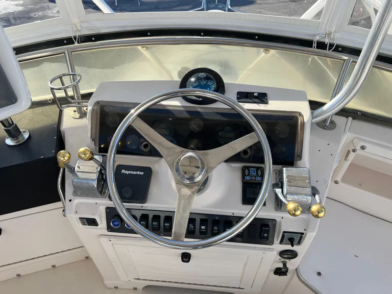Slide: The Image of 1992 Blackfin 29 Flybridge helm with steering wheel, controls, and Raymarine equipment. - 14