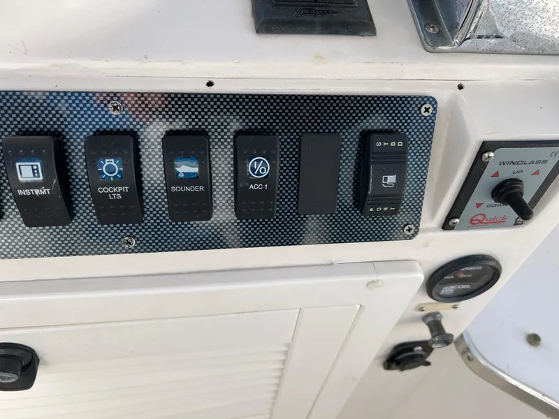 Slide: The Image of Control panel of a 1992 Blackfin 29 Flybridge boat with various switches and gauges. - 15