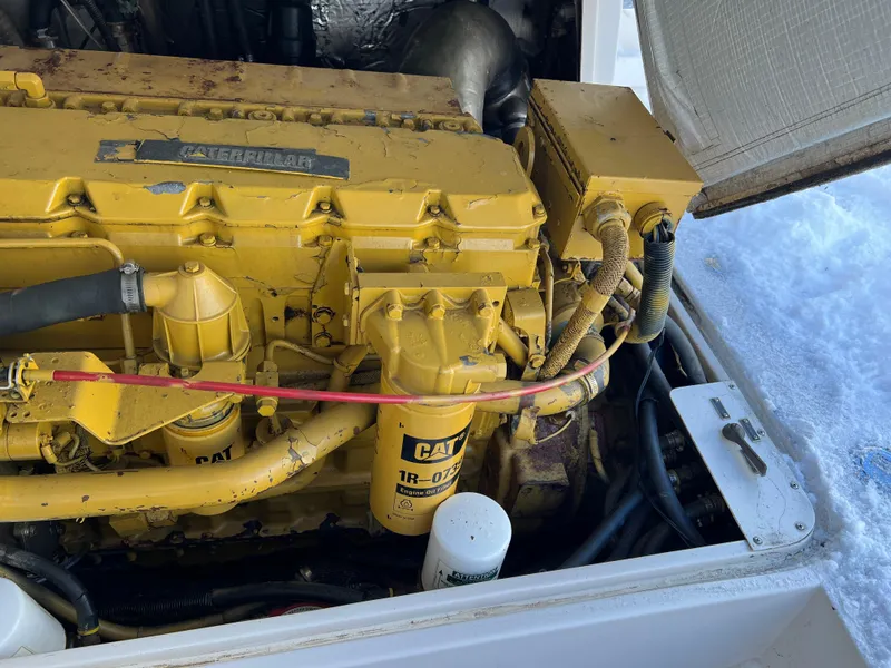 Slide: The Image of Yellow Caterpillar engine in a 1992 Blackfin 29 Flybridge boat, partially covered in snow. - 32