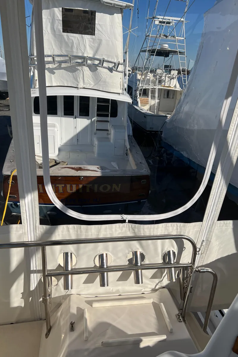 Slide: The Image of 1992 Blackfin 29 Flybridge boat docked, surrounded by other vessels, with clear blue sky. - 9